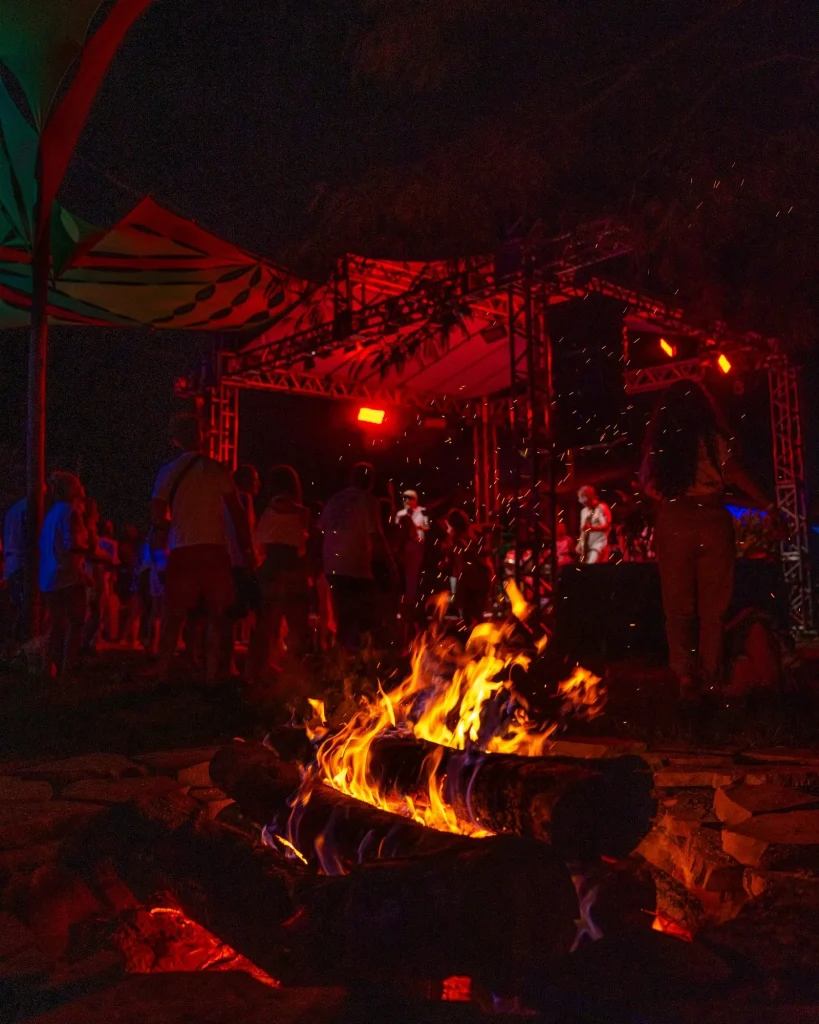 Festa noturna com luzes vermelhas e fogueira